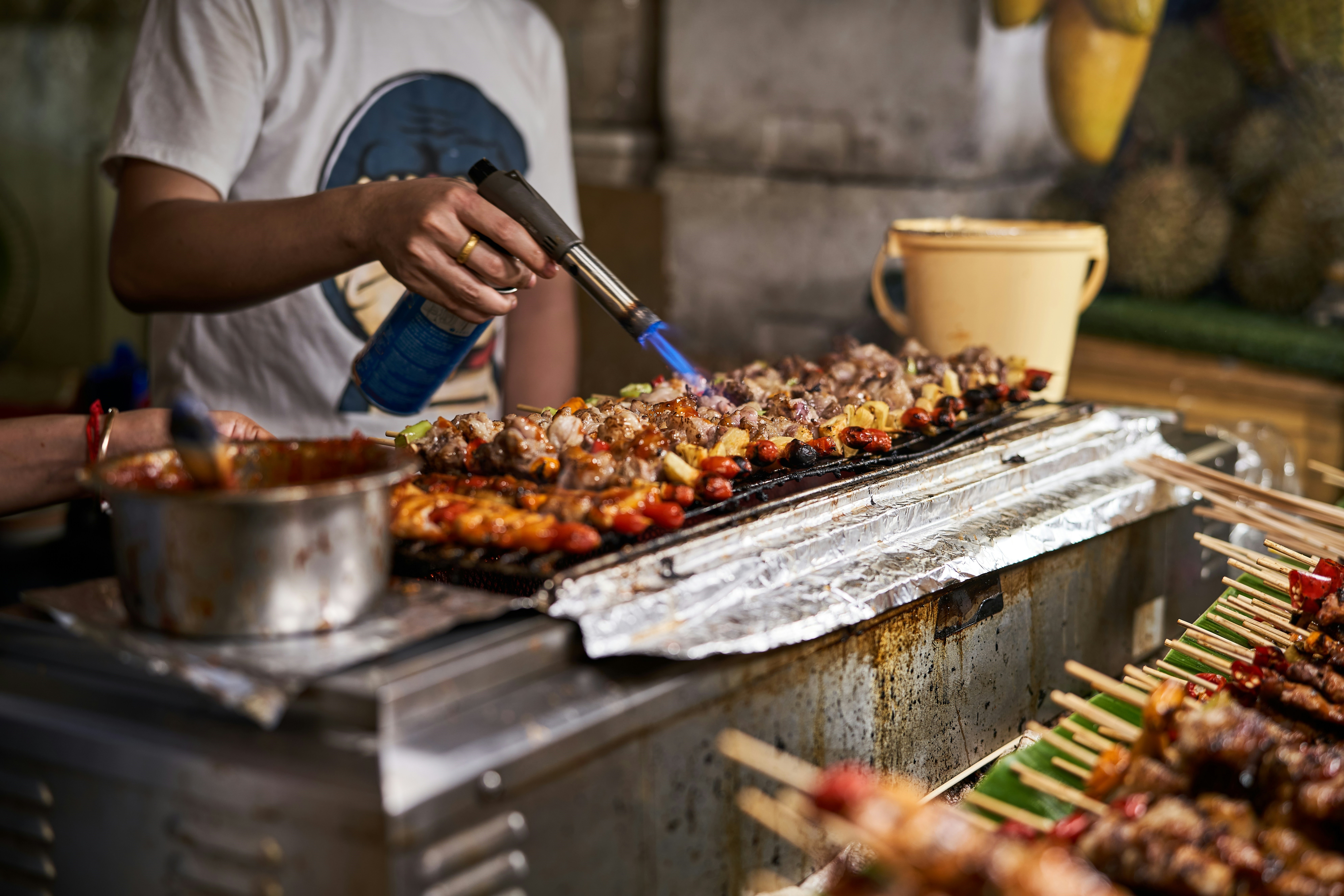 person-cooking-food-on-a-grill, street food, night market, thailand